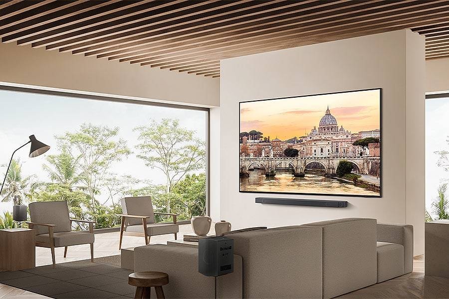 Salon moderne doté d'un grand téléviseur mural SAMSUNG TQ75QN85D affichant un paysage urbain pittoresque et un mobilier contemporain élégant.
