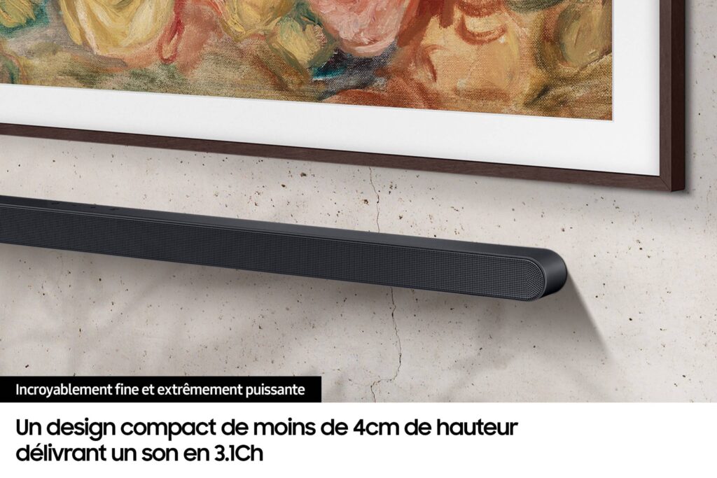 Une élégante barre de son SAMSUNG HW-S710D montée sous un tableau encadré sur un mur, avec un texte en français décrivant sa conception compacte et sa qualité sonore impressionnante.