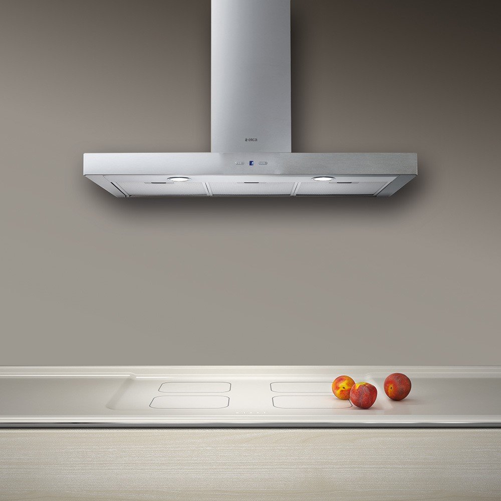 Une hotte de cuisine moderne en acier inoxydable ELICA CRUISE IX/A/90 installée au-dessus d'une table de cuisson avec trois nectarines sur le comptoir.
