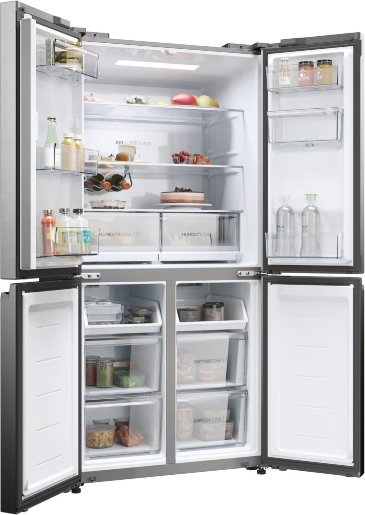 Le réfrigérateur HAIER HCW58F18EWMP est ouvert, révélant une multitude d'aliments, de boissons et de contenants soigneusement organisés dans les sections réfrigérateur et congélateur.