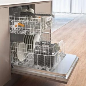 Ouvrez le lave-vaisselle MIELE G 5150 VI, rempli d'assiettes, de bols et d'ustensiles, situé dans une cuisine moderne dotée de parquet.