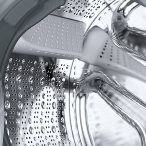 Gros plan de l'intérieur du tambour d'une machine à laver SIEMENS WG44G2F2FR, présentant des gouttes d'eau scintillant sur la surface métallique.