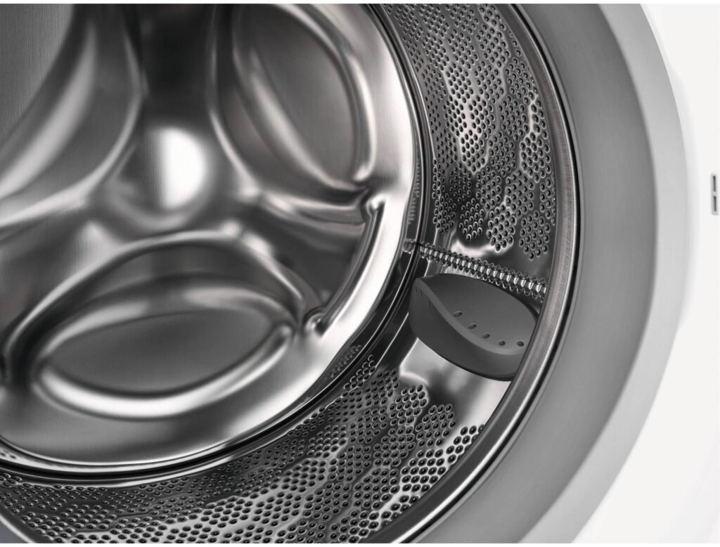 Gros plan d'un tambour vide de la machine à laver ELECTROLUX EW6F5814BA, mettant en valeur son design élégant en acier inoxydable perforé.