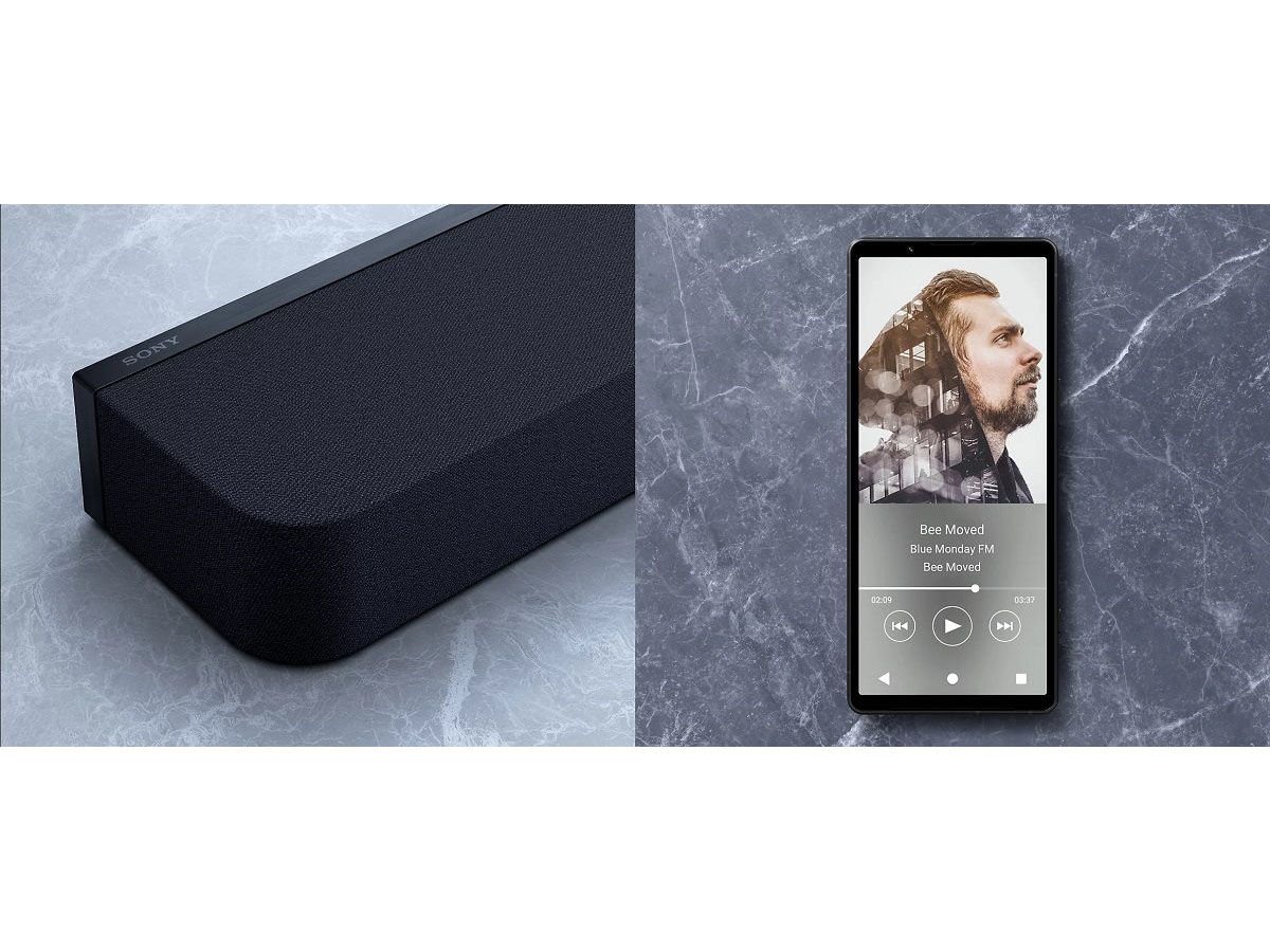 Une élégante enceinte noire SONY HTA9000 BRAVIA Theatre Bar 9 et un smartphone affichant de la musique reposent élégamment sur une surface en marbre, créant une expérience de divertissement parfaite.