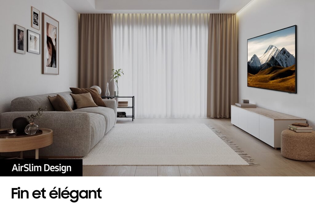 Rehaussez l'élégance moderne de votre salon avec le téléviseur SAMSUNG TU65DU8575, doté d'un design AirSlim. Fixé au mur, il s'associe parfaitement à un canapé gris et à des rideaux beiges, créant ainsi un espace élégant et raffiné.
