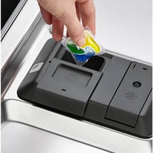 Une main insère une dosette de détergent vibrante dans le compartiment de l'élégant lave-vaisselle ELECTROLUX EES48320L.