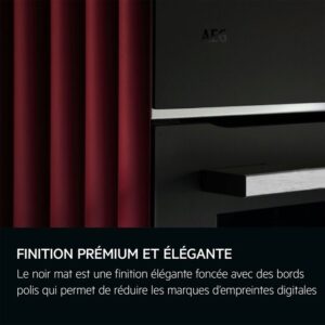 Gros plan de l'appareil AEG TT9PB831AT avec une finition noire mate élégante sur un rideau rouge, décrit dans le texte français comme incarnant la sophistication et le luxe haut de gamme.