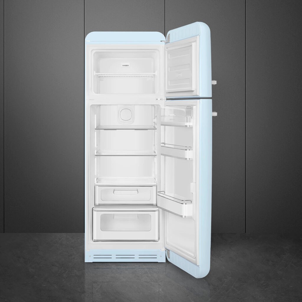 Le réfrigérateur rétro SMEG FAB30RPB5, présenté avec sa porte ouverte pour exposer des étagères et des tiroirs vides, présente une finition bleu clair qui se détache sur un fond sombre.
