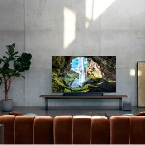 Salon moderne avec une grande télévision montrant la nature, un canapé marron, une plante en pot et une élégante barre de son SAMSUNG HW-Q995D (Copie) pour un son immersif.