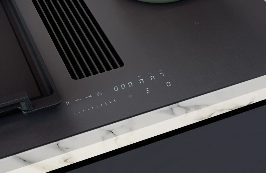 Gros plan de la table de cuisson NOVY 1861-G1 EASY MATT LINE avec commandes tactiles numériques, posée contre un bord de comptoir en marbre.