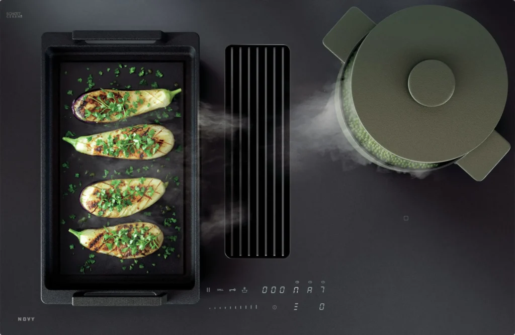 Des aubergines grillées et une marmite fumante sont posées sur l'élégant poêle noir moderne NOVY 1861-G1 EASY MATT LINE.