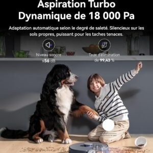 Un gros chien et un enfant souriant sont assis à côté de l'aspirateur robot NARWAL FREO Z10 ULTRA GRIS pendant qu'il nettoie les croquettes renversées sur le parquet.