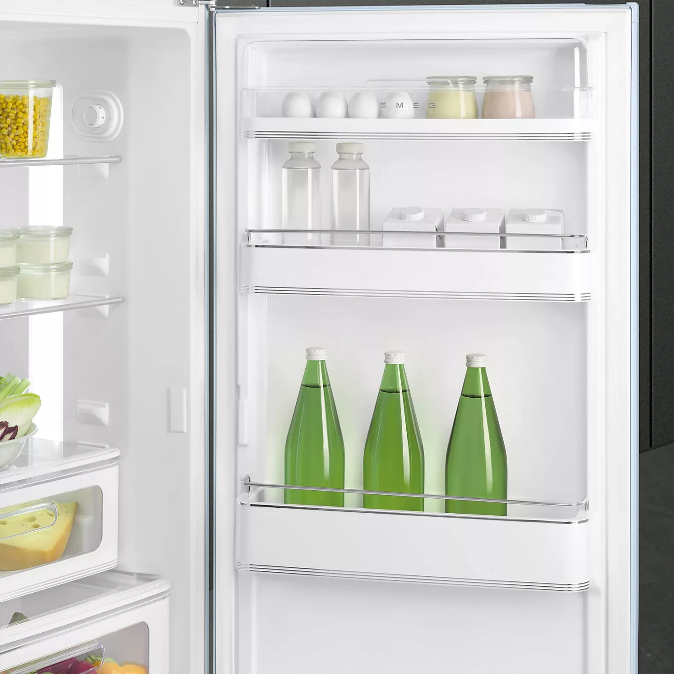 Ouvrez la porte du réfrigérateur SMEG FAB30RPB5 pour découvrir des œufs, des bocaux, des bouteilles et des boissons bien rangés sur les étagères de la porte au style rétro.