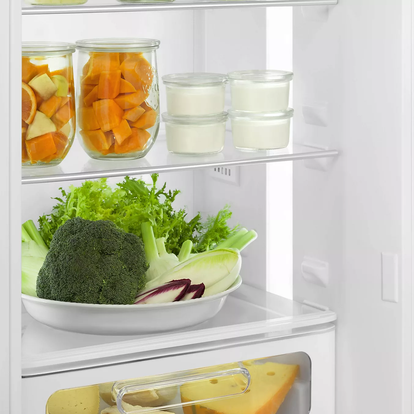 L'étagère du réfrigérateur SMEG FAB30RPB5 accueille des bocaux de fruits coupés, des pots de yaourt et une assiette de légumes frais.