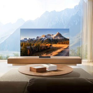 Salon moderne doté d'un grand téléviseur TCL 75C8K affichant un paysage de montagne, avec une cheminée et une vue imprenable sur les montagnes visibles à travers de hautes fenêtres.