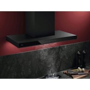 Une cuisine contemporaine est équipée de la hotte noire AEG GB87D91CB au-dessus de la cuisinière. La vapeur s'échappe gracieusement d'une casserole, mettant en valeur les tons rouges et verts vibrants.