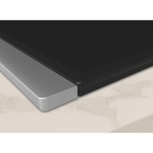 Gros plan de la table de cuisson NEFF V57THQ4L0, élégante et moderne, avec une surface en verre noir et une garniture argentée, parfaitement intégrée au plan de travail de cuisine de couleur claire.