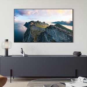 Un salon moderne avec une armoire sombre, une décoration de bon goût et une grande photo de montagne est rehaussé par l'élégant téléviseur SAMSUNG TQ100QN80F accroché au mur, ajoutant de la sophistication à l'espace.