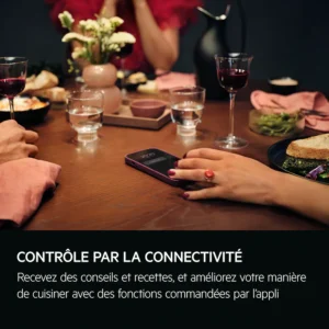 Une table à manger dressée avec de la nourriture, des boissons, un smartphone et le grille-pain AEG TA5PB53XAB, avec des personnes en train de dîner et d'interagir.