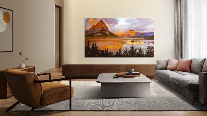 Salon moderne avec un téléviseur TCL 43P79K fixé au mur au-dessus de canapés, un fauteuil et une table basse.