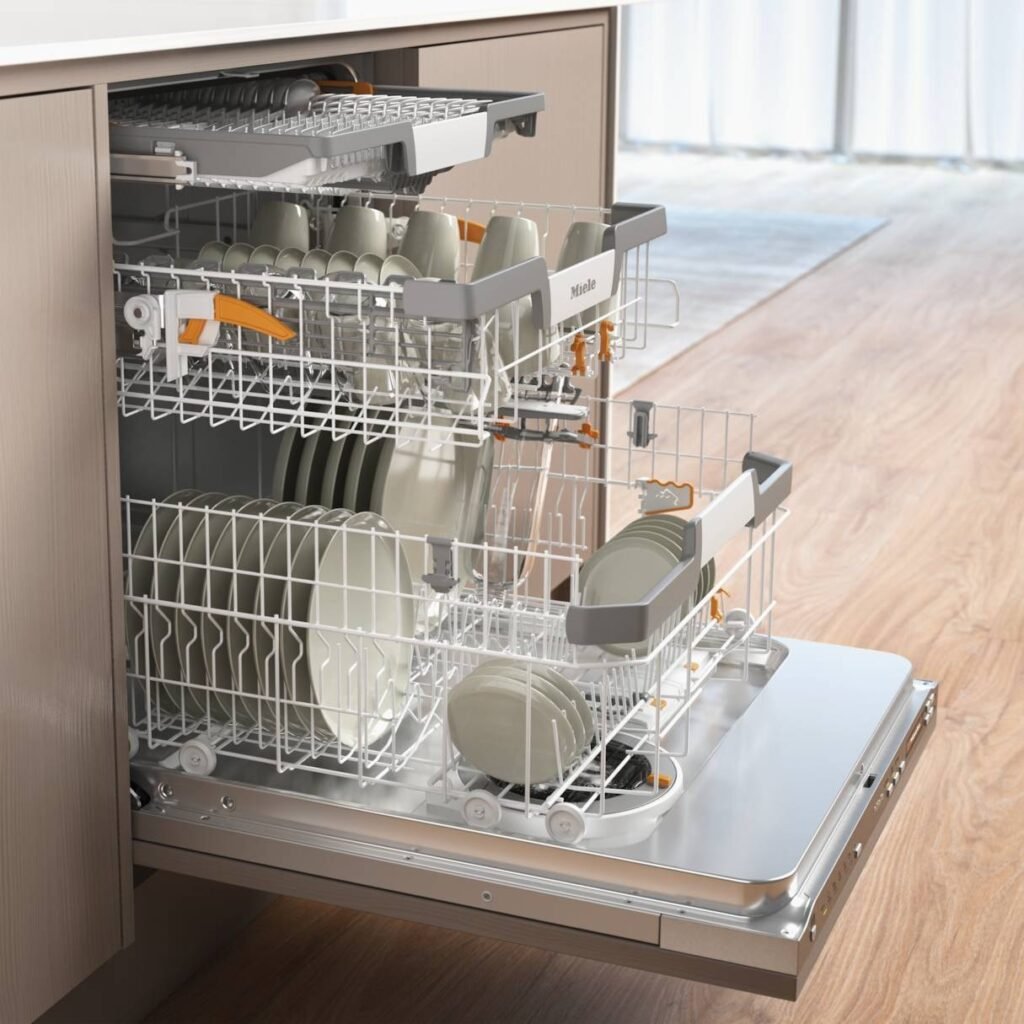 Une cuisine moderne présente le MIELE G 7180 SCVI AUTODOS, entièrement chargé d'assiettes, de bols et de tasses propres, mettant en valeur sa fonction AUTODOS avancée.
