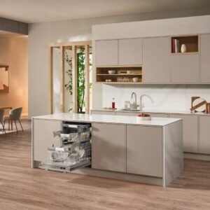 Cuisine moderne avec armoires beiges, lave-vaisselle ouvert MIELE G 7180 SCVI AUTODOS, îlot et salle à manger en arrière-plan.