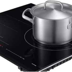 Une casserole en acier inoxydable avec couvercle repose sur la table de cuisson noire de la plaque à induction SAMSUNG NZ63B6056GK, dotée de commandes numériques intuitives.