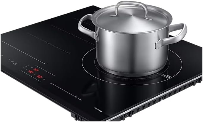 Une casserole en acier inoxydable avec couvercle repose sur la table de cuisson noire de la plaque à induction SAMSUNG NZ63B6056GK, dotée de commandes numériques intuitives.