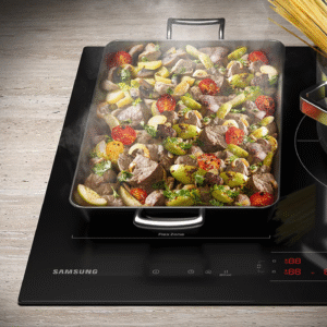 Une cuisinière SAMSUNG NZ63B6056GK avec une casserole de viande et de légumes en train de cuire à côté d'une marmite de pâtes en train de bouillir.