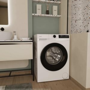 Une buanderie moderne comprenant la machine à laver à chargement frontal blanche CANDY GD49B8-S à côté d'un évier et d'un espace douche.