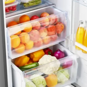 En ouvrant le réfrigérateur HISENSE FL372BIE, vous trouverez des fruits frais, des légumes et des bouteilles de jus de fruits bien rangés sur les étagères et dans les tiroirs.