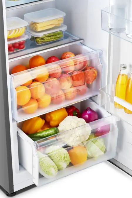 En ouvrant le réfrigérateur HISENSE FL372BIE, vous trouverez des fruits frais, des légumes et des bouteilles de jus de fruits bien rangés sur les étagères et dans les tiroirs.