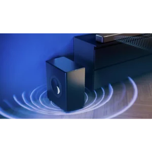 Un caisson de basse PHILIPS TAFW1/10 noir est posé à côté d'un meuble TV sur un sol en bois, contre un mur bleu, et émet des ondes sonores.