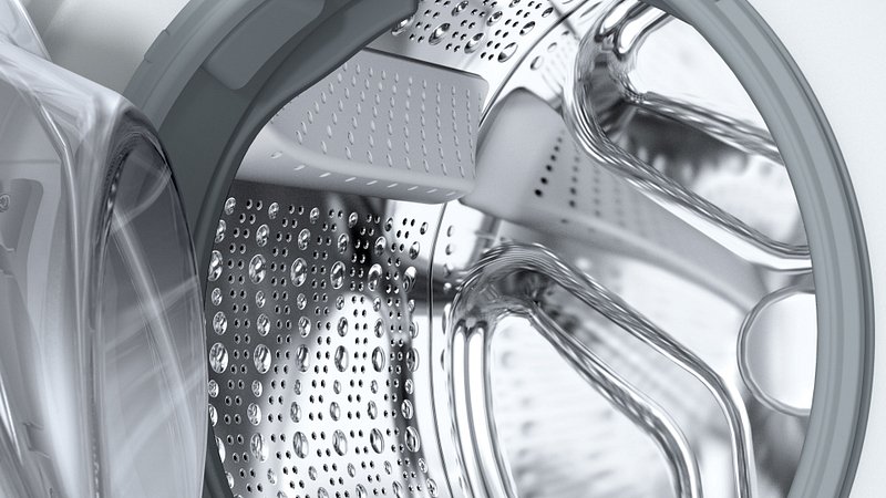 Vue rapprochée de l'intérieur du tambour du lave-linge SIEMENS WG56H2A5FR, montrant des gouttes d'eau sur la surface métallique.