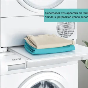 Une pile de linge plié est posée sur une étagère coulissante entre des appareils SIEMENS WQ46H2CAFR empilés, soulignant l'efficacité et le design moderne de ces appareils Siemens.