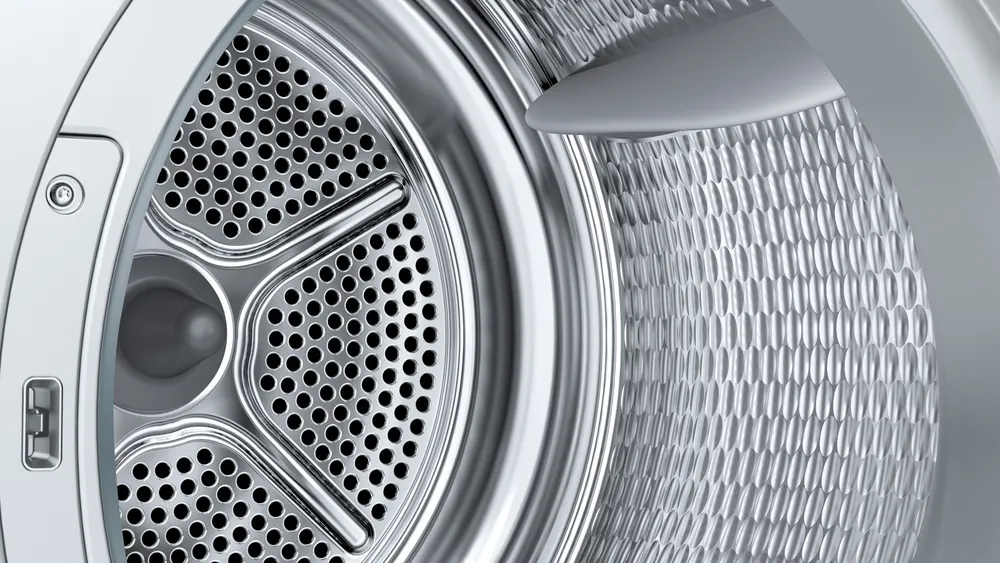 Gros plan de l'intérieur du tambour du lave-linge SIEMENS WQ46H2CAFR, mettant en évidence ses trous métalliques et sa surface texturée.