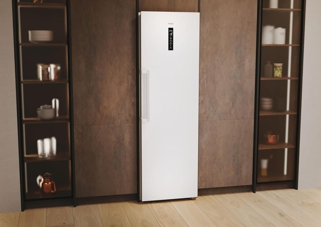 Le réfrigérateur HAIER H4F306WDH1, un grand réfrigérateur blanc à affichage numérique, est placé entre deux étagères en bois remplies d'ustensiles de cuisine.