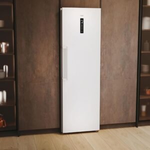 Le réfrigérateur HAIER H4F306WDH1, un grand réfrigérateur blanc à affichage numérique, est placé entre deux étagères en bois remplies d'ustensiles de cuisine.