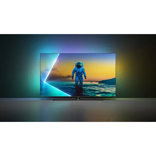 Le téléviseur PHILIPS 65OLED850/12 OLED montre un astronaute debout sur l'eau, avec un rétroéclairage vif et coloré qui illumine le mur derrière l'écran.