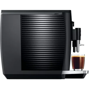 Vue latérale de la JURA E4 PIANOBLACK, qui prépare élégamment le café dans une tasse en verre.