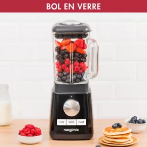 Un mixeur MAGIMIX 11628 est posé sur un comptoir, rempli de baies et entouré de fruits, de crêpes et d'un verre de lait.