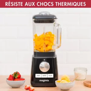 Un mixeur MAGIMIX 11628 noir, rempli de mangue hachée, est entouré de fraises et de coupes de glace.