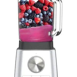 Un mixeur MAGIMIX 11630 argenté rempli d'un smoothie rose, garni de baies assorties telles que des fraises et des mûres.