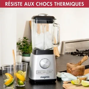 Un mixeur MAGIMIX 11630, rempli de glace, est posé sur le comptoir d'une cuisine à côté de verres décorés de tranches de citron et de citron vert.