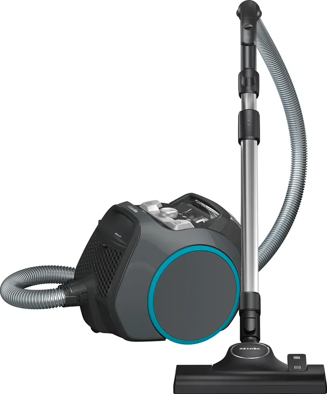Le Miele BOOST CX1 POWERLINE est un aspirateur-traîneau de couleur grise et noire, doté d'un tuyau flexible et d'un tube d'aspiration en métal.
