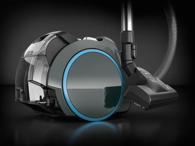 Le Miele BOOST CX1 POWERLINE est un aspirateur-traîneau moderne au design épuré et rond avec un anneau bleu sur la roue.