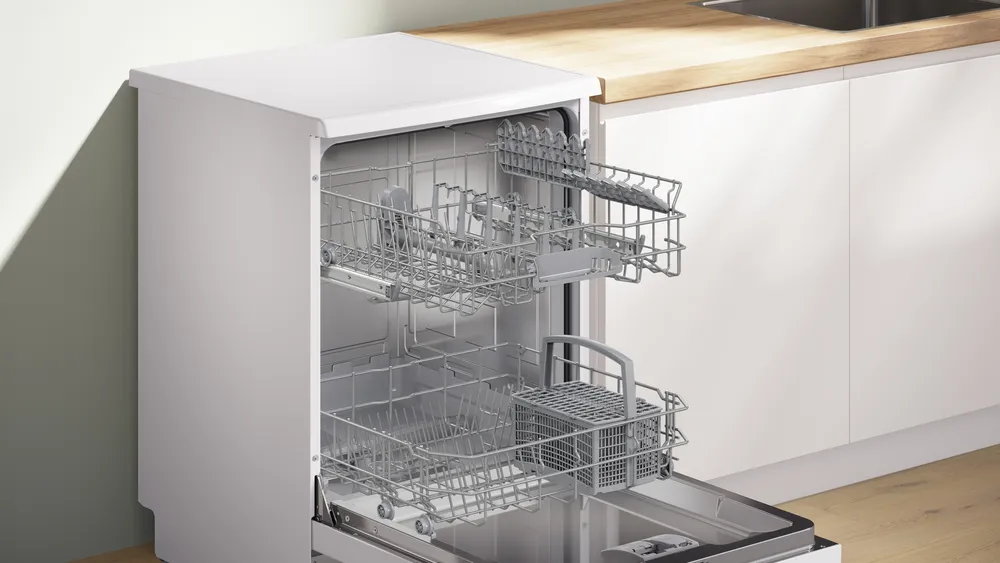 Le lave-vaisselle BOSCH SMS25AW10F trône dans une cuisine lumineuse, sa porte étant ouverte pour mettre en valeur les casiers vides et le design moderne et épuré.