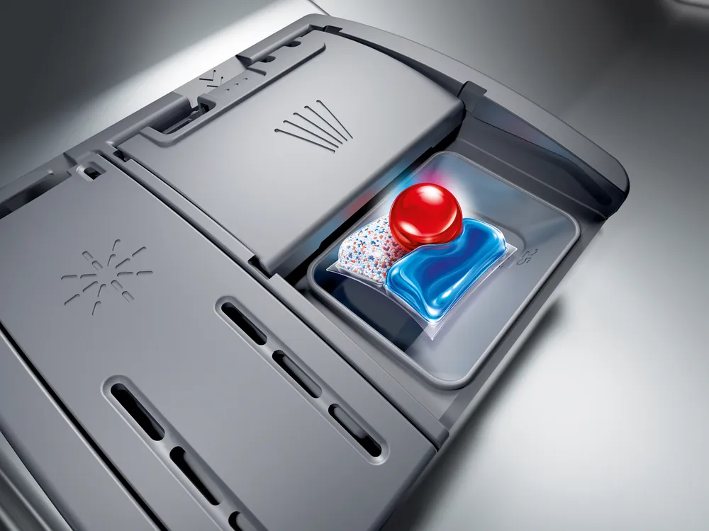 Compartiment à détergent d'un lave-vaisselle BOSCH SMS25AW10F avec une dosette à l'intérieur, prêt à fonctionner.