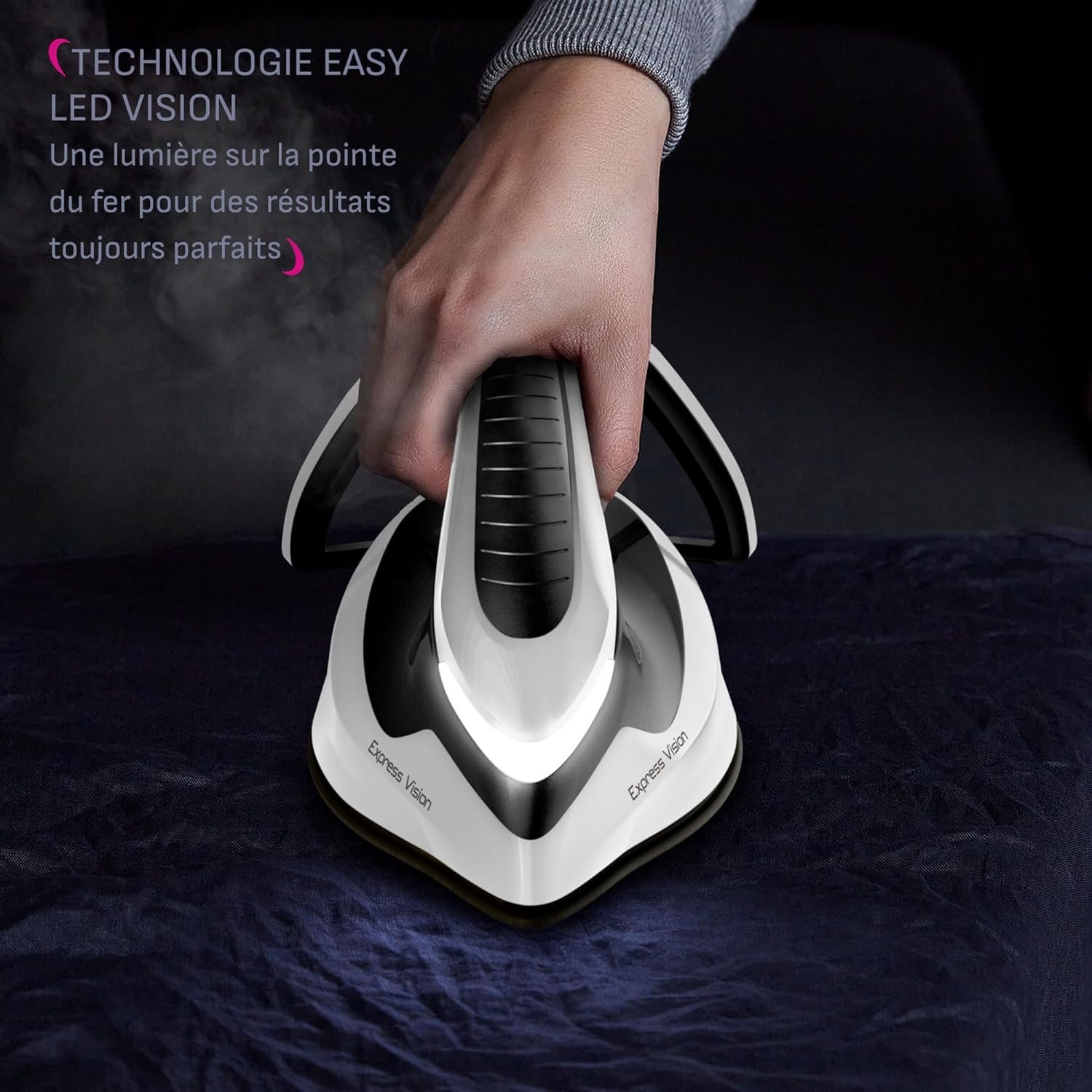 Une main repasse un tissu sombre avec le CALOR SV8156CO, un fer à repasser moderne équipé d'une lumière LED à son extrémité.