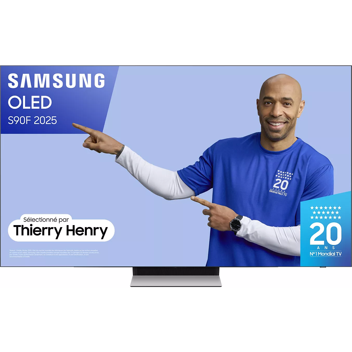 Un homme en chemise bleue montre un écran de télévision SAMSUNG TQ77S90F avec un texte promotionnel.